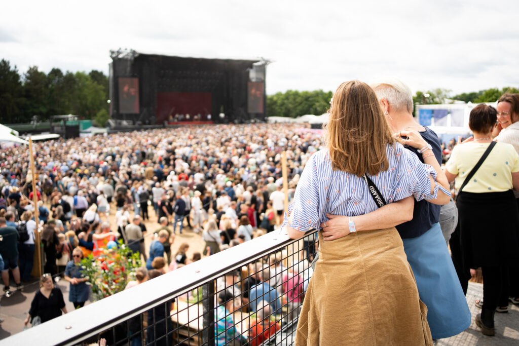 Par på balkon overskuer det store publikum foran Jelling Musikfestivals hovedscene